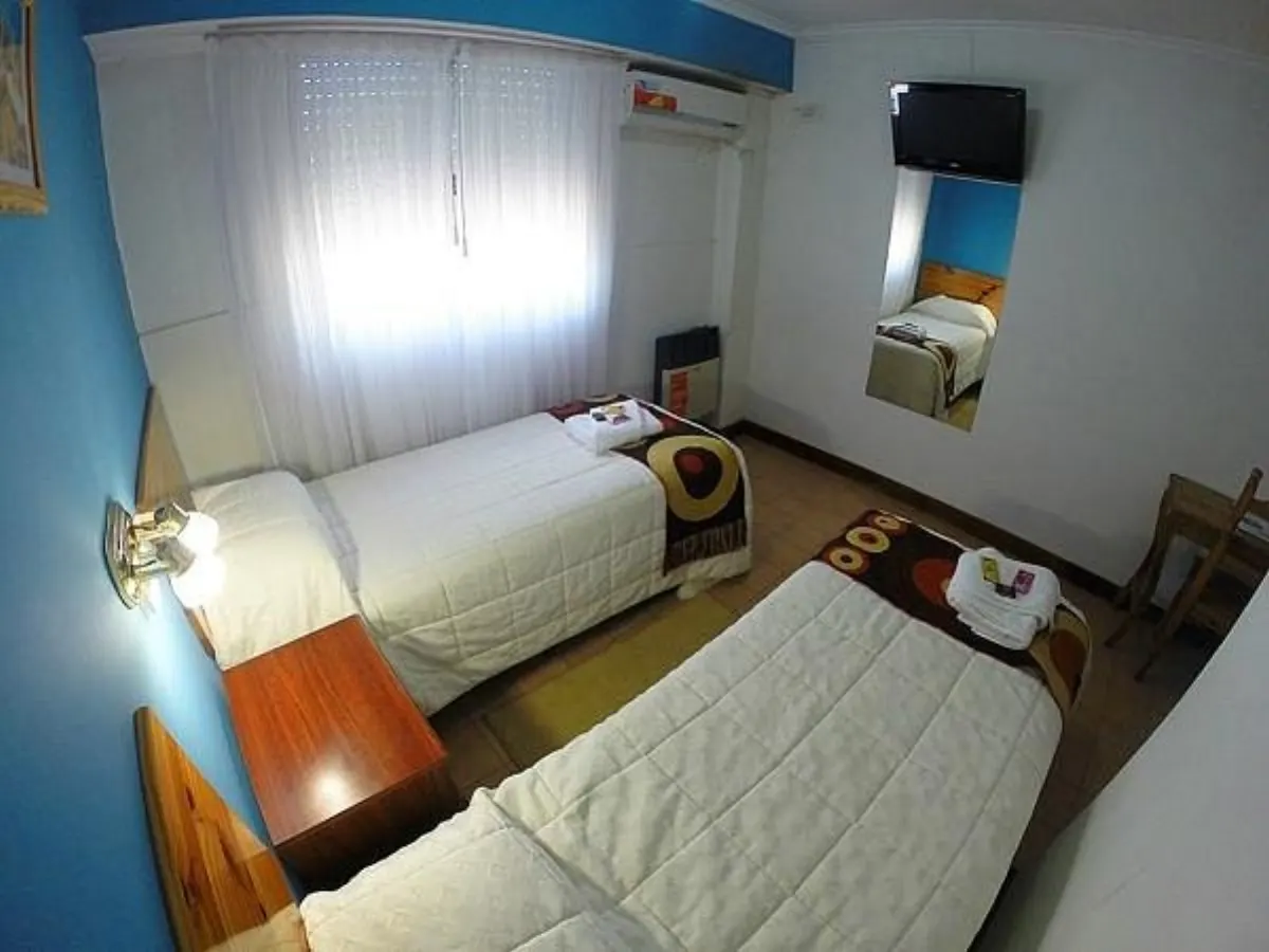 Habitación con dos camas individuales, pared celeste