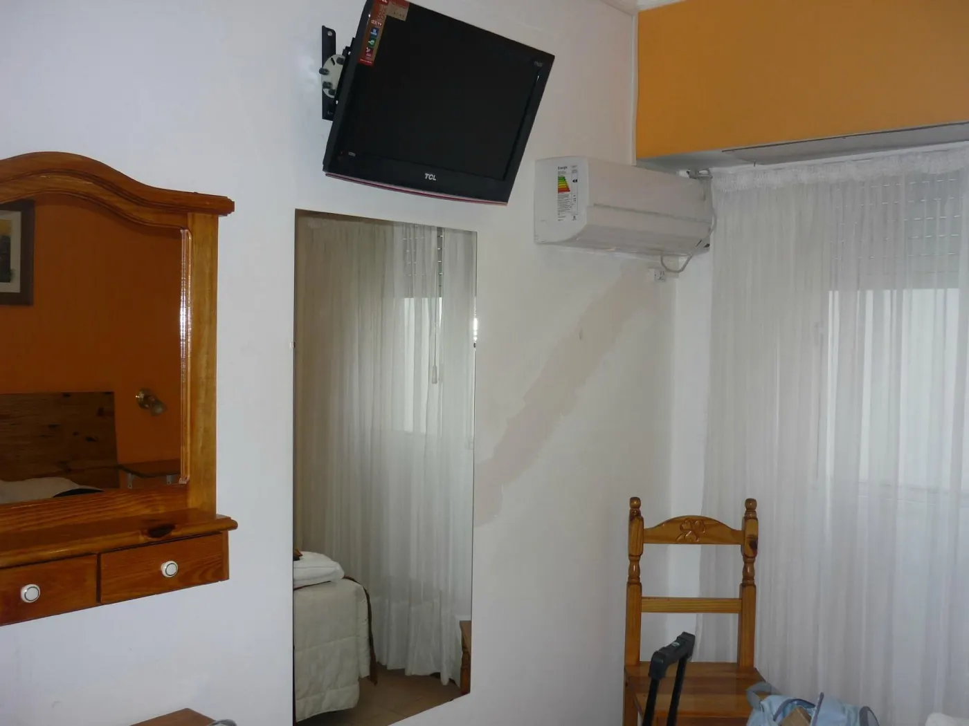 Habitación doble, pared naranja con TV