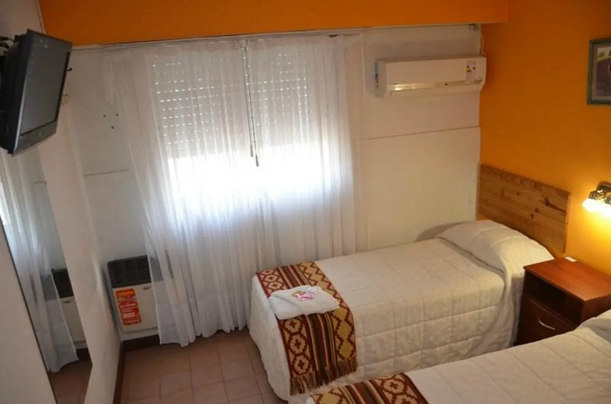 Habitación con camas individuales, pared naranja